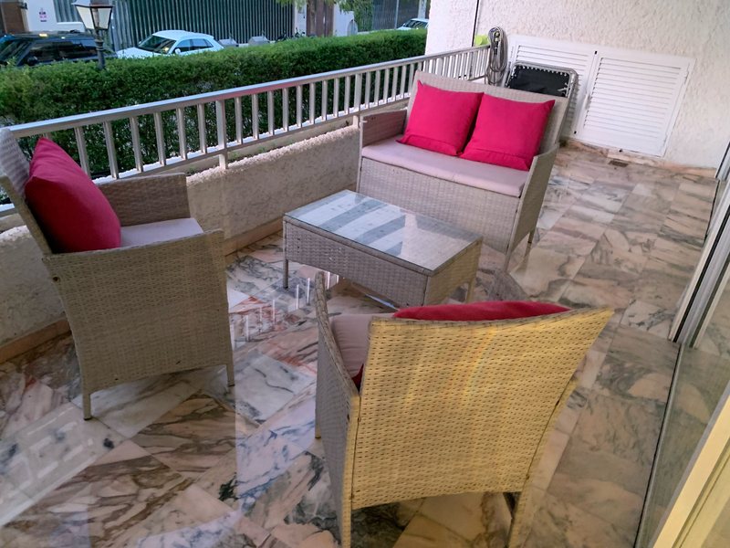 Terrace with wicker furniture and marble floor in Sierra Blanca