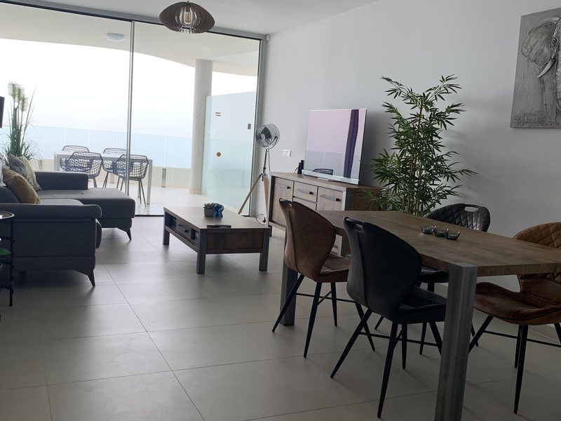 Living and dining room with ocean view balcony in Puerto Banus
