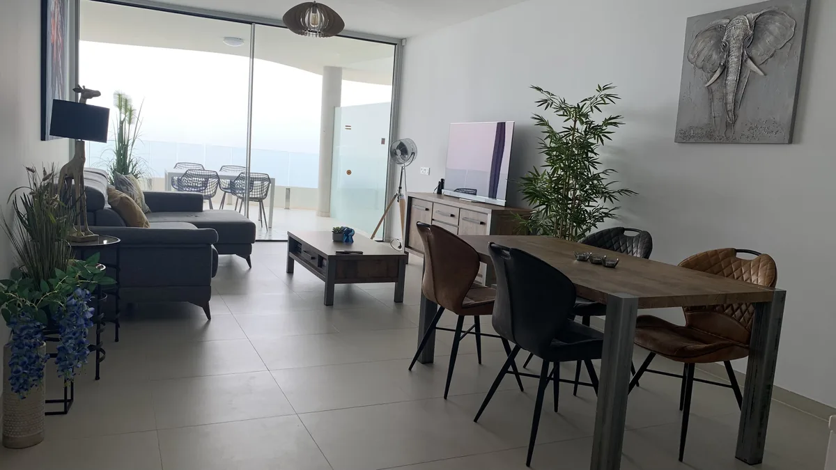 Living and dining room with an ocean-view balcony in Puerto Banus